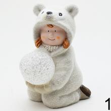 Dve deti v zimných oblekoch s LED guľou.