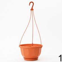 Závesný kvetináč v oranžovej a bielej farbe.