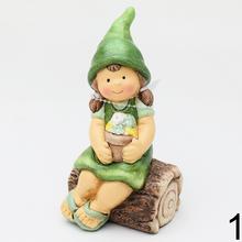 Detské keramické postavičky sediace na drevených kmeňoch.