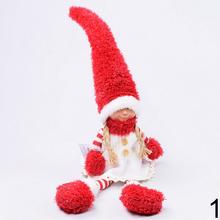 Vianoční škriatkovia sediaci chlapec a dievča s červenými klobúkmi.