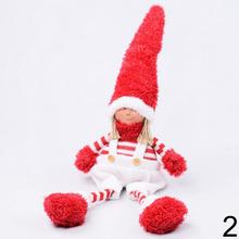 Vianoční škriatkovia sediaci chlapec a dievča s červenými klobúkmi.