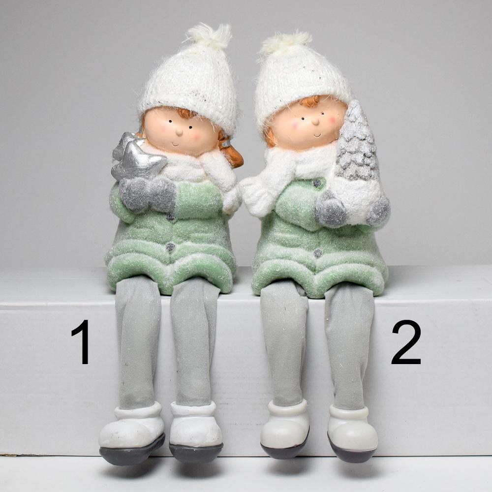 Dvě děti s visícími nohama v tyrkysové barvě, oblečené v zimních bundách a čepicích.