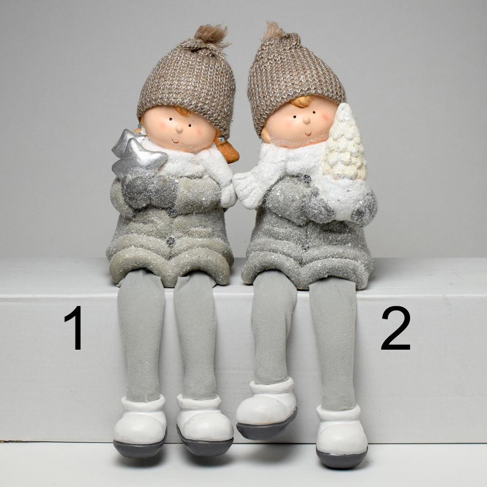 Dvě děti se šedýma nohama, oblečené v zimních čepicích a šálách, drží v rukou vánoční dekorace.