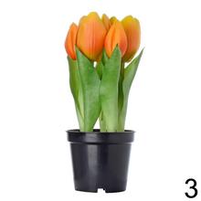 Umelé tulipány v čiernom kvetináči.