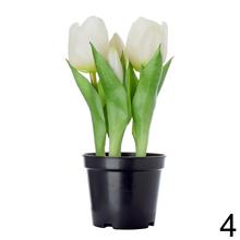 Umelé tulipány v čiernom kvetináči.