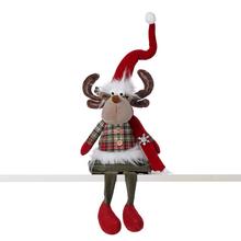 Textilní figurka soba sedícího s červenou čepicí a šálou.