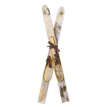 Dekorační lyže ze dřeva se zlatými detaily.