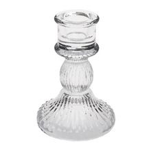 Sklenený svietnik s ružovou sviečkou.