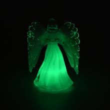 Sviečka v tvare anjela s bielymi krídlami.