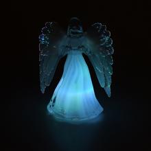 Sviečka v tvare anjela s bielymi krídlami.