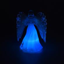 Sviečka v tvare anjela s bielymi krídlami.