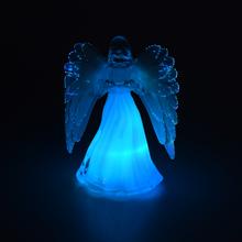 Sviečka v tvare anjela s bielymi krídlami.