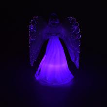 Sviečka v tvare anjela s bielymi krídlami.