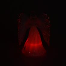 Sviečka v tvare anjela s bielymi krídlami.