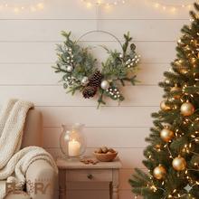 Vianočný veniec s čečinou, zelenými vetvičkami, šiškami a bielymi bobuľami.