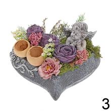 Smútočná väzba s kvetinami a sochou anjela.