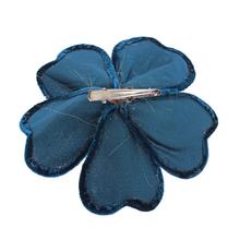 Umelý kvet na klipe v zelenej farbe s ozdobnými detailmi.