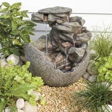 Fontána s okrúhlym kameňom a vodopádom.