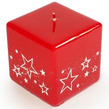 Červená svíčka ve tvaru kostky s bílými hvězdami.