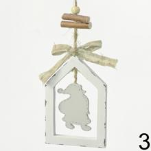 Bílá dřevěná závěsná dekorace ve tvaru domečku s mixem vzorů.