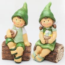 Dětské keramické figurky sedící na dřevěných kmenech.