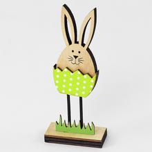 Dřevěný zajíček ve skořápce se zelenou barvou a tečkami.