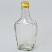 Skleněná láhev o objemu 250 ml se zlatým víčkem.