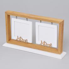 Bílý fotorámeček se dřevěným rámem a nápisem Home.