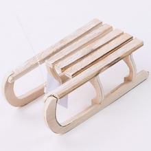 Dřevěné saně v přírodní barvě, malé, s rozměry 16x8x5,5 cm.