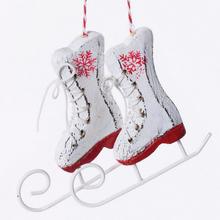 Bílé brusle ze dřeva a kovu na vánoční dekoraci.