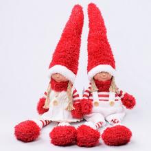 Vánoční skřítci sedící chlapec a dívka s červenými čepicemi.