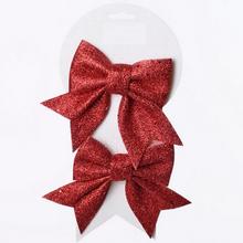 Červené třpytivé mašle na vánoční dekorace.