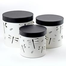 Dárková krabička se třemi válci v bílé barvě s černým vrchem.