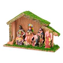 Dřevěný betlém se soškami postav a trávou.