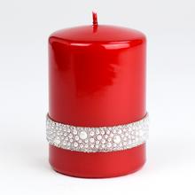 Červená svíčka s dekorativním páskem.