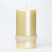 Vánoční svíčka s opálovým vzhledem a metalickým krémovým povrchem.