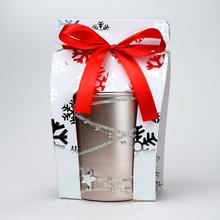 Vonná svíčka ve skleněném obalu s růžovým zlatem a červenou stuhou.