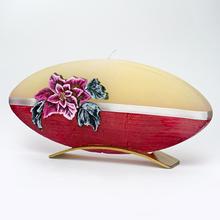 Vánoční svíčka ve tvaru oválné hvězdy s květinovým motivem.