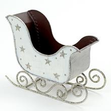 Bílé a stříbrné saně s hvězdami.