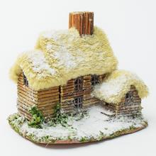 Domek z přírodních materiálů s detaily sněhu.