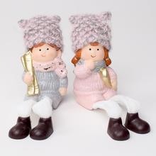 Dvě keramické postavičky dětí v zimních oblečcích s čepicemi.