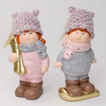 Dvě keramické postavičky dětí v zimních čepicích a šálách.