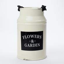 Obal váza krémové barvy s nápisem Flowers & Garden.