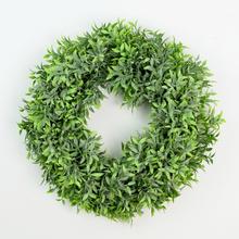 Umělý věnec z krušpánu ve světle zelené barvě o průměru 28 cm.