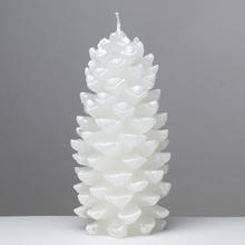 Bílá svíčka ve tvaru šišky.