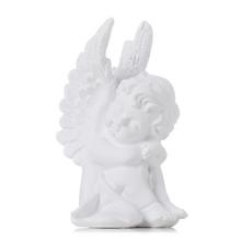 Bílý sedící anděl s křídly.