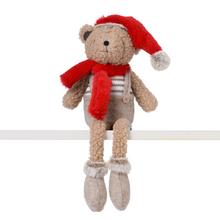 Béžový medvěd sedící s červenou čepicí a šálou.