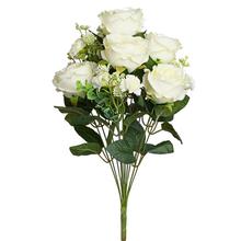 Kytice pivoňky v krémové barvě s drobnými květy a zelení.