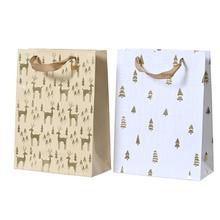 Vánoční papírové tašky s glitry ve zlaté a bílé barvě.