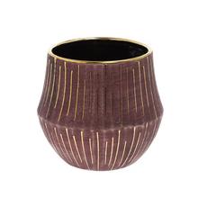 Kulatý obal burgundské barvy se zlatými detaily.